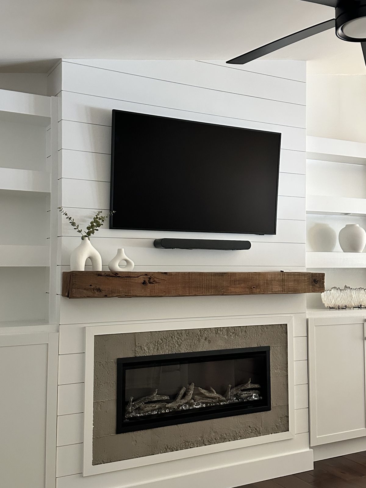Reclaimed wood mantel on shiplap fireplace surround